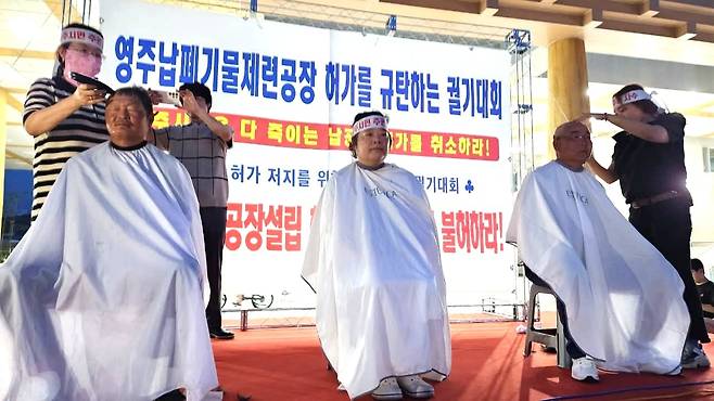 영주 납폐기물공장 반대 3차 열린 지난 3일 영주역에 설치된 중앙무대에서 시민3명이  납공장을 반대하는 삭발에 참여했다 [서영교 더불어민주당 의원 사회관계망서비스(SNS) 갈무리]