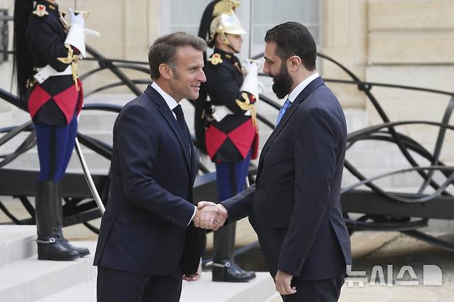 [파리=AP/뉴시스] 에마뉘엘 마크롱(왼쪽) 프랑스 대통령과 아흐마드 알샤라 시리아 과도정부 대통령이 7일(현지 시간) 프랑스 파리 엘리제궁에서 회담에 앞서 악수하고 있다. 알샤라 대통령은 바샤르 알아사드 독재정권 붕괴 이후에서 서방의 제재가 유지되는 건 부당하다면서 제재 해제를 촉구했고 마크롱 대통령은 이의 점진적 해제를 약속했다. 2025.05.08