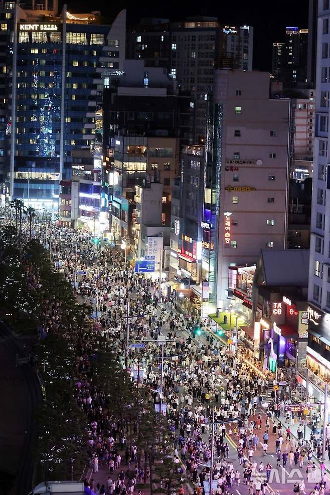 [부산=뉴시스] 하경민 기자 = 폭염특보와 열대야 현상으로 인해 밤낮으로 푹푹 찌는 더위가 이어진 5일 밤 부산 수영구 광안리해수욕장 해안도로가 '차 없는 도로'로 통제돼 시민과 관광객들로 북적이고 있다. 2025.07.06. yulnetphoto@newsis.com