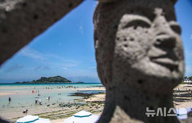 [제주=뉴시스] 우장호 기자 = 폭염의 기세가 수그러들지 않는 6일 오후 제주시 한림읍 금능해수욕장을 찾은 피서객들이 시원한 바닷물에 발을 담그며 더위를 식히고 있다. 2025.07.06. woo1223@newsis.com