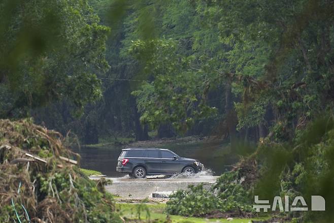 [AP/뉴시스] 크리스티 놈 국토안전부 장관을 태운 차량이 큰 인명 피해가 난 미스틱 캠프를 둘러본 뒤 강을 건너고 있다