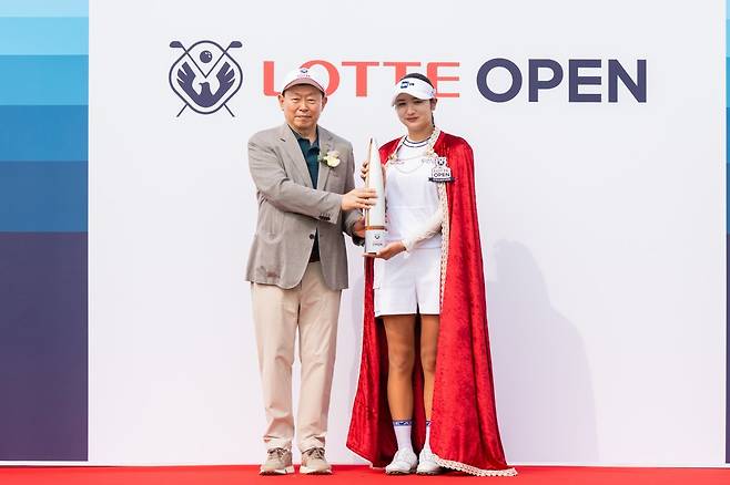 제15회 롯데 오픈에서 데뷔 4년 만에 첫 승을 거둔 박혜준(오른쪽)이 롯데그룹 신동빈 회장으로부터 롯데월드타워를 형상화한 챔피언 트로피를 전달받은 뒤 기념 포즈를 취하고 있다. 사진제공 | 롯데