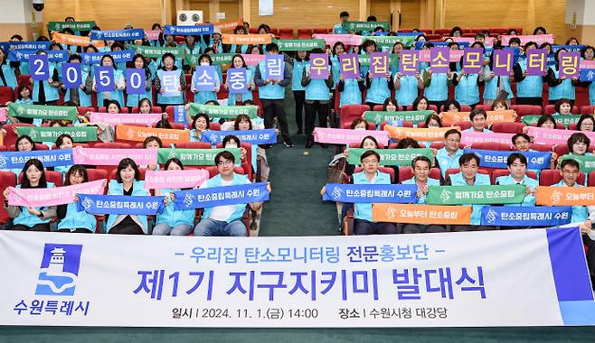 지난해 11월 1일 수원시청 대강당에서 열린 '우리집 탄소모니터링' 사업 전문홍보단 제1기 지구지키미 발대식 참석자들이 탄소중립과 관련한 팻말을 들고 기념 촬영을 하고 있다. 사진=수원시청