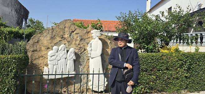 파티마에서 성모를 발현한 세 어린이들의 조각상 앞에 서 있는 김정수 바르나바 신부.