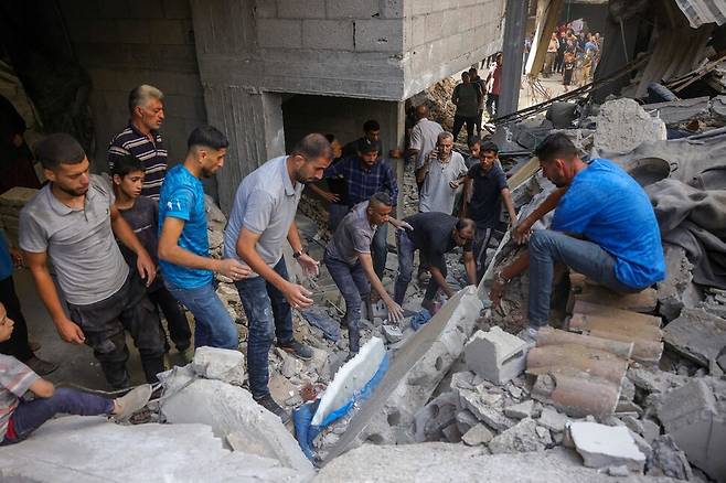 6일(현지시각) 이스라엘의 공습 대상이 된 가자지구 가자시티의 건물 잔해에서 사람들이 생존자를 찾고 있다. 가자시티티/AFP 연합뉴스
