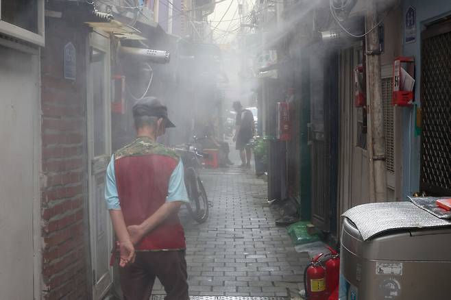 7일 오후 서울 종로구 돈의동 쪽방촌에서 주민들이 쿨링포그 아래서 더위를 식히고 있다. 김영원 기자 forever@hani.co.kr