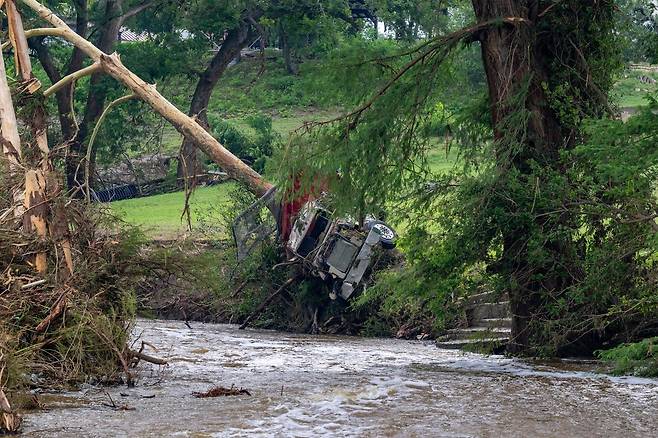 6일(현지시간) 미국 텍사스주 센터포인트(Center Point) 지역의 과달루페강(Guadalupe River) 강변에서 한 대형 트럭이 거대한 나무에 관통되듯 박혀 있는 모습. AFP연합뉴스