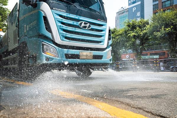 도로 열기 식히자- 부산의 낮 최고기온(중구 대청동 관측소 기준)이 34도까지 치솟는 등 전국적으로 불볕 더위가 이어진 7일 부산 동래구 사직야구장 일원에 부산환경공단 살수차량이 노면에 물을 뿌리고 있다. 전민철 기자 jmc@kookje.co.kr