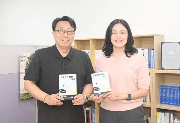 양민호(사진 왼쪽) 최민경 교수가 공저한 부산 사투리에 관한 책 ‘쓰잘데기 있는 사전’을 들어보이고 있다. 국립부경대 제공