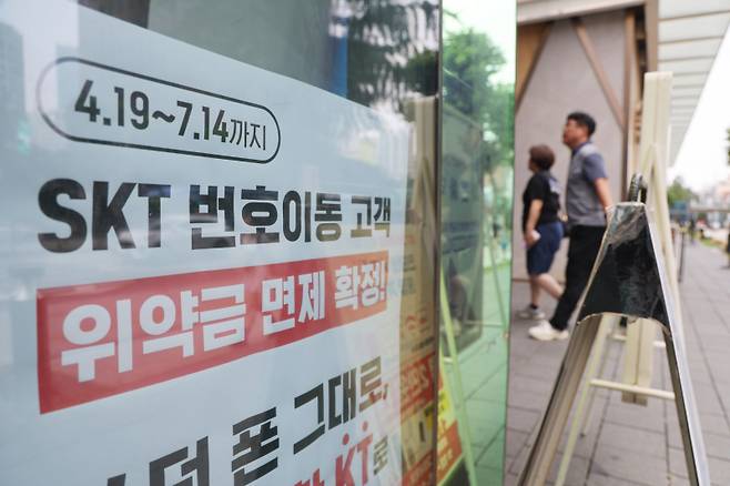 서울 시내의 한 KT 매장에 SK텔레콤 번호이동 고객에 대한 위약금 면제 안내문이 붙어있다. 연합뉴스