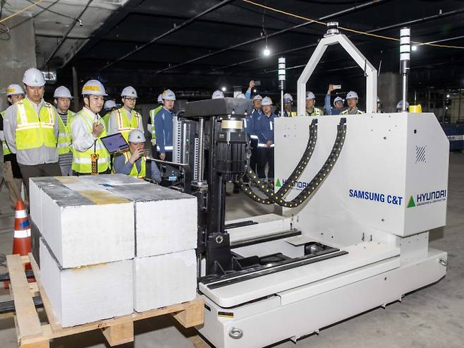 현대건설과 삼성물산이 건설현장에서 반복되는 자재 운반 작업을 자동화하고 작업자와 장애물을 인식해 안전 운행하는 로봇을 공동 개발했다. 사진은 ‘스마트 자재 운반 로봇’이 현장에서 자재를 싣고 자율주행 이동하는 모습. /사진=삼성물산·현대건설