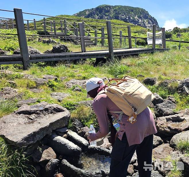 [제주=뉴시스] 임재영 기자 = 6일 오전 한라산 영실탐방로에 있는 노루샘에서 등산객이 물을 담고 있다. 2025.07.07. ijy788@newsis.com