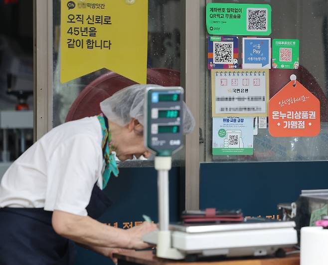 정부가 민생회복 소비쿠폰 1차 지급계획을 발표한 6일 서울의 한 전통시장 점포에 기존 골목경제 소비 활성화를 위한 온누리상품권 가맹 팻말이 붙어 있다. 연합뉴스