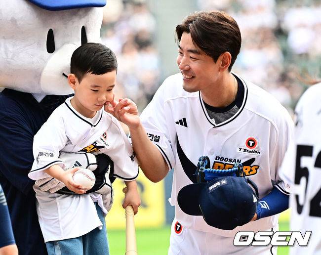 [OSEN=잠실, 지형준 기자] 6일 오후 서울 잠실구장에서 ‘2025 신한 SOL Bank KBO리그’ 두산 베어스와 KT 위즈의 경기가 열렸다.두산은 최승용, KT는 엔마누엘 데 헤이수스를 선발로 내세웠다.두산은 이날 2024시즌을 끝으로 은퇴를 선언한 김재호의 은퇴식을 개최한다. 은퇴식 테마는 ‘베어스 올타임 No.1 유격수 김재호’이다. 김재호는 은퇴선수 특별 엔트리를 통해 1군 엔트리에도 이름을 올렸다.&nbsp;김재호가 막내 아들과 시구, 시타를 마치고 있다. 2025.07.05 /jpnews@osen.co.kr