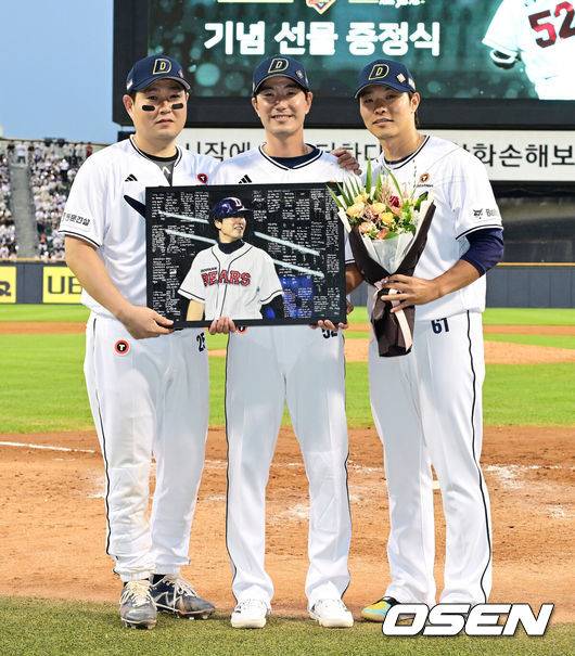 [OSEN=잠실, 지형준 기자] 6일 오후 서울 잠실구장에서 ‘2025 신한 SOL Bank KBO리그’ 두산 베어스와 KT 위즈의 경기가 열렸다.두산은 최승용, KT는 엔마누엘 데 헤이수스를 선발로 내세웠다.두산은 이날 2024시즌을 끝으로 은퇴를 선언한 김재호의 은퇴식을 개최한다. 은퇴식 테마는 ‘베어스 올타임 No.1 유격수 김재호’이다. 김재호는 은퇴선수 특별 엔트리를 통해 1군 엔트리에도 이름을 올렸다.&nbsp;클리닝타임 김재호가 선물 전달식을 갖고 KT 양의지, 최원준과 사진 촬영을 하고 있다. 2025.07.05 /jpnews@osen.co.kr