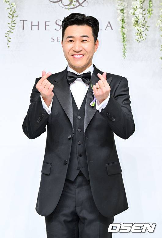 [OSEN=박준형 기자] 가수 김종민은 20일 서울 중구 장충동 신라호텔 영빈관에서 11살 연하 예비 신부와 결혼식을 올린다.예비 신부가 비연예인인 만큼 혼자 포토월에 서는 김종민은 간단한 인터뷰에 응하며 간단한 소감을 전했다. 김종민이 포즈를 취하고 있다.   2025.04.20 / soul1014@osen.co.kr