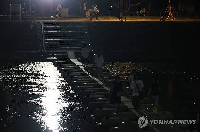 대구도 잠 못 드는 밤 (대구=연합뉴스) 박세진 기자 = 열대야가 이어진 7일 대구 신천에서 시민들이 산책하며 더위를 나고 있다. 2025.7.7 psjpsj@yna.co.kr