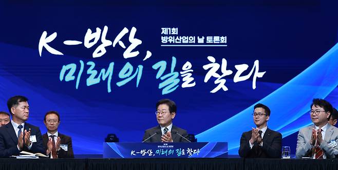 이재명 대통령이 8일 서울 그랜드 하얏트 호텔에서 열린 방위산업의 날 토론회에서 참석자 소개를 듣고 있다. 연합뉴스