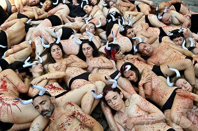 5일(현지시간) 스페인 팜프로나에서 열릴 산 페르민 축제를 앞두고 옷을 벗은 동물보호단체 활동가들이 몸에 피를 묻힌채 '엔시에로'와 투우 경기를 반대하는 시위를 하고 있다.ⓒ AFP=뉴스1