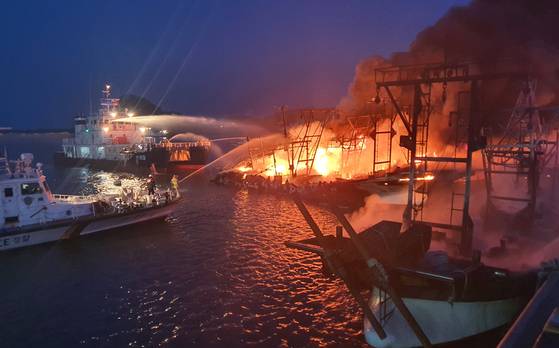 지난 2021년 3월 23일 충남 태안군 근흥면 신진도에 정박 중이던 어선에서 불이 나자 119 소방대원들이 긴급 출동해 해경 함정 간판 위에서 진화작업을 벌이고 있다. 연합뉴스