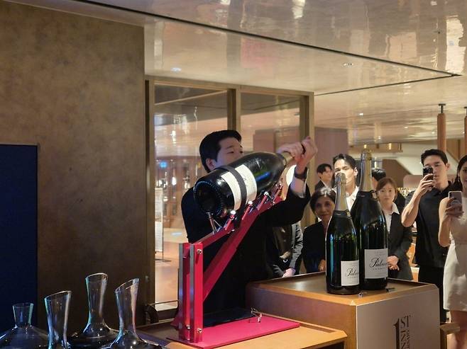 지난달 14일 하우스오브신세계 와인셀라에서 진행된 1주년 기념 행사에서 소믈리에가 6L짜리 팔머앤코 샴페인을 열고 있다. / 사진=라현진 기자