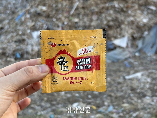 마을을 뒤덮은 플라스틱 쓰레기 속에서 ‘신라면 볶음면 치즈맛’ 스프를 발견했다. 신라면 볶음면 치즈맛은 농심이 일본에서만 파는 제품이다. 오경민 기자