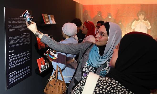 Visitors take a selfie at the "K-Comics World” exhibition at the Korean Cultural Center in Cairo, July 1. (KOCCA)
