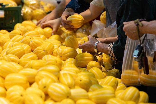 Shoppers pick out Korean melons at a large supermarket in Seoul on June 22. [NEWS1]