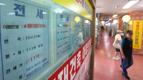 서울 시내의 한 부동산에 붙은 전세 매물 안내문 앞으로 시민이 지나고 있다. [사진 출처 = 연합뉴스]