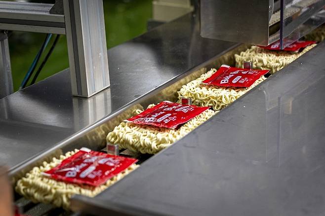 삼양식품 밀양2공장에서 불닭볶음면 소스를 면 위에 올리는 공정이 진행되고 있다. [사진 = 삼양식품]
