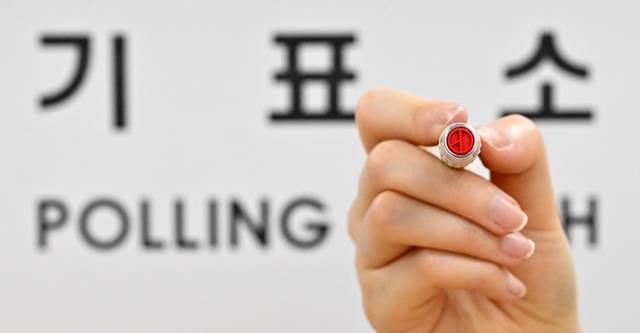 제21대 대통령 선거를 하루 앞둔 2일 서울 용산구 청파도서관에 마련된 청파동 제1투표소에서 관계자가 기표 도장을 들어 보이고 있다. 공동취재단