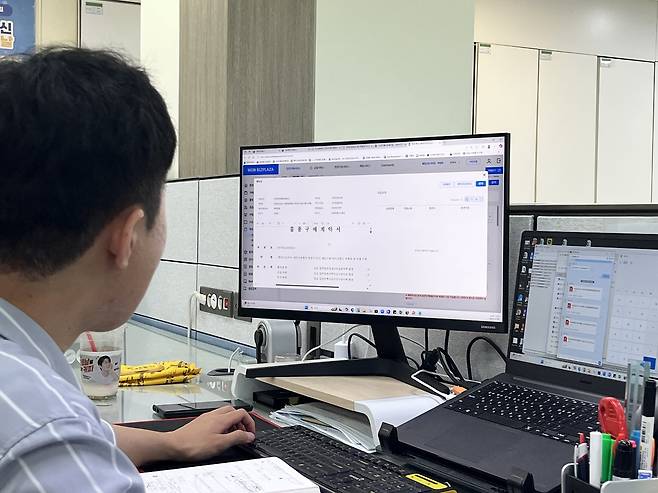 지능형 교통시스템 개발·운영사인 대보정보통신 구매팀 직원이 우리은행의 ‘원비즈플라자’ 프로그램을 통해 물품구매계약서를 살펴보고 있다. [대보정보통신 제공]