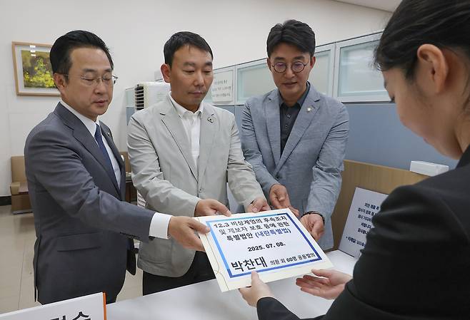박성준(왼쪽부터), 김용민, 노종면 더불어민주당 의원이 8일 서울 여의도 국회 의안과에서 박찬대 의원이 발의한 ‘내란특별법’ 안을 제출하고 있다. [연합]