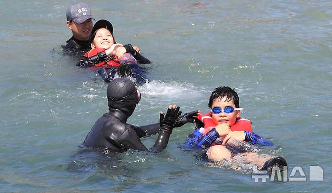 [서귀포=뉴시스] 우장호 기자 = 8일 오전 제주 서귀포시 법환 해녀체험장에서 제주도교육청과 해녀·해군기동함대사령부가 협동해 강정초등학교 학생들에게 '제주형 생존수영' 교육을 하고 있다. 이번 생존수영 교육은 법환 어촌계 해녀, 해군 해난구조대(SSU)가 함께하는 전국 최초의 프로그램으로 서귀포시 관내 초등학교 5~6학년 학생 100여명(3개교)을 대상으로 8월15일까지 운영된다. 2025.07.08. woo1223@newsis.com