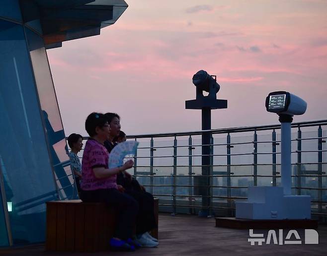 [광주=뉴시스] 이현행 기자= 8일 오후 광주 남구 사동에 위치한 사직공원 전망대에서 시민들이 더위를 피하며 노을을 감상하고 있다. 2025.07.08 lhh@newsis.com