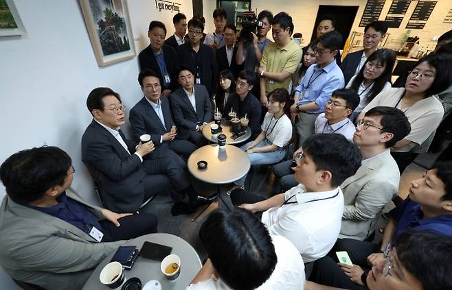 이재명 대통령과 김민석 국무총리, 강훈식 대통령비서실장이 8일 용산 대통령실 직원식당에서 식사 후 매점에서 만난 기자들과 차를 마시며 대화하고 있다. 2025.7.8 뉴시스