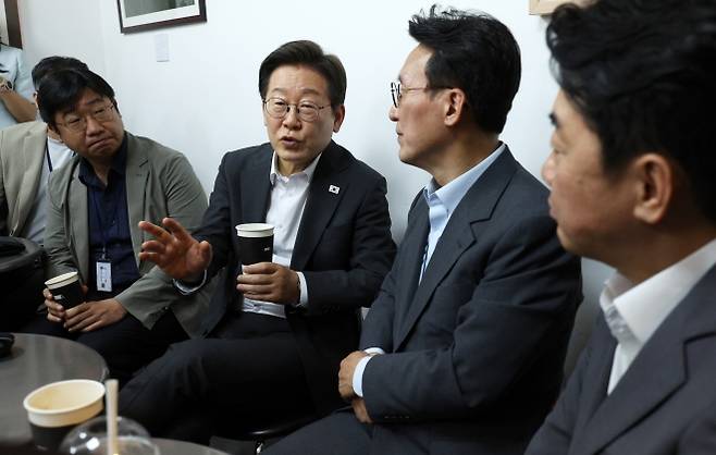 이재명 대통령과 김민석 국무총리, 강훈식 대통령비서실장이 8일 용산 대통령실 직원식당에서 식사 후 매점에서 만난 기자들과 차를 마시며 대화하고 있다. 2025.7.8 뉴시스