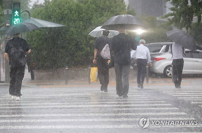 퇴근길 폭우 (서울=연합뉴스) 박동주 기자 = 서울 서남권에 호우주의보가 발효된 8일 서울 영등포구 여의도 국회 인근에서 시민들이 우산을 쓰고횡단보도를 건너고 있다. 2025.7.8 pdj6635@yna.co.kr
