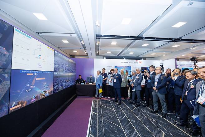 지난달 열린 ETRI 콘퍼런스 2025 전시장에서 관람객들이 지상-위성 통합 6G 초공간 통신 기술 시연을 관람하고 있다.