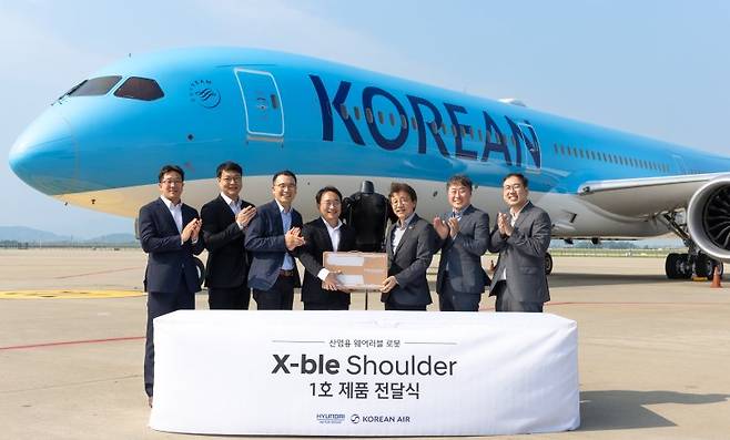 현대차·기아 로보틱스랩과 대한항공 항공우주사업본부 주요 참석자들이 지난 8일 인천 중구 대한항공 정비고에서 산업용 착용로봇 '엑스블 숄더' 1호 전달식 후 기념 촬영을 하고 있다. 현대자동차·기아 제공