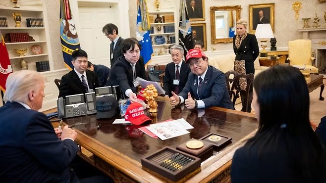 지난 4월 도널드 트럼프 미국 대통령을 만난 아자카와 료세이 일본 경제재생상이 마가(MAGA·미국을 다시 위대하게) 모자를 쓰고 있다. 로이터연합뉴스