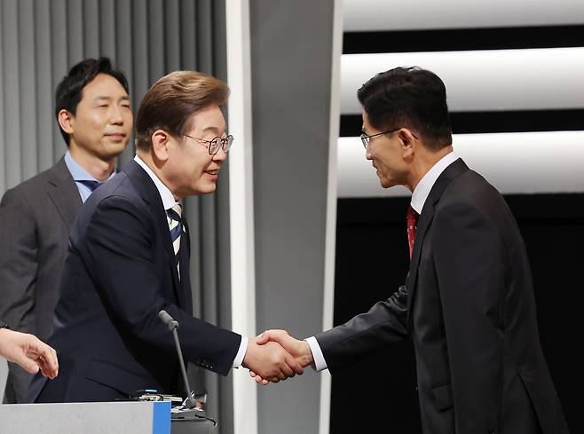 Lee Jae-myung of the Democratic Party, left, greets Kim Moon-soo of the People Power Party ahead of the second televised presidential debate on May 23 at the KBS studio in Yeongdeungpo District, western Seoul. [JOINT PRESS CORPS]
