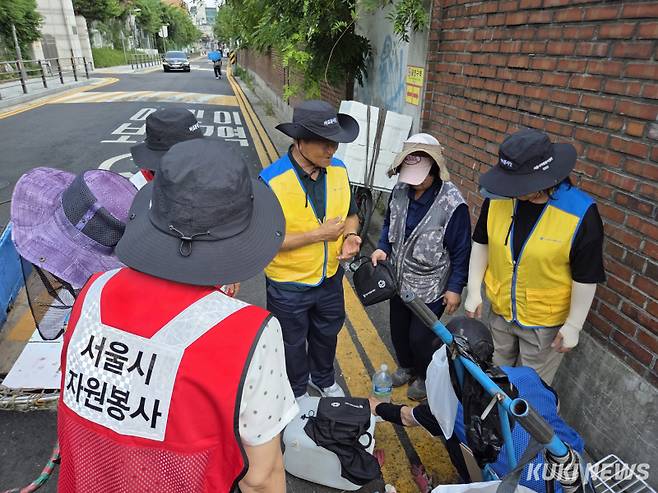 8일 오후 3시 서울 성동구 마장중학교 앞에서 ‘재난 대응 바로봉사단’이 폐지 줍는 어르신들에게 쿨키트를 나눠주고 있다. 노유지 기자