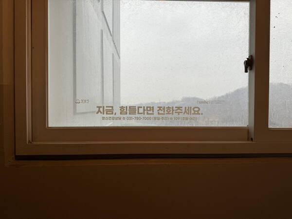 성남시 ‘안전으뜸마을’ 사업의 창문 시트 작업. 취약계층 주거지를 중심으로 자살예방센터 안내 문구와 플래카드 등을 부착해 상담으로 연계하는 해당 사업은 지난 2018년부터 시작돼 매년 5~6건의 상담으로 이어지고 있다. 성남시자살예방센터 제공