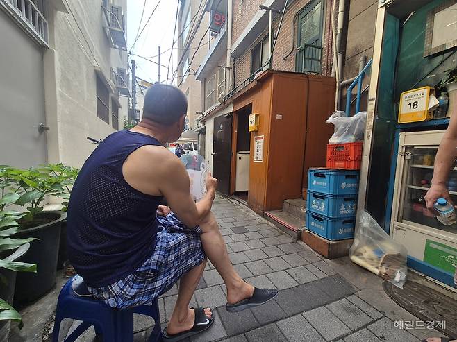 9일 오전 서울 종로구 돈의동 쪽방촌 골목에 한 주민이 나와 부채질을 하고 있다. 김도윤 기자.