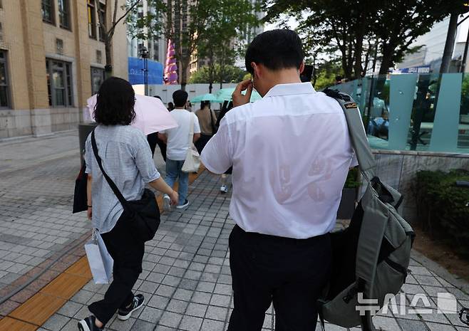 [서울=뉴시스] 최진석 기자 = 폭염이 이어지고 있는 8일 서울 세종대로사거리 인근에서 출근길 시민의 셔츠가 땀으로 젖어 있다. 2025.07.08. myjs@newsis.com