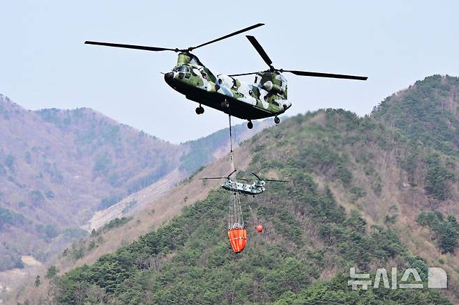 [하동=뉴시스] 차용현 기자 = 경남 하동군 옥종면 산불 발생 2일째를 맞은 8일 오전 주불을 잡기 위해 투입된 치누크 군용헬기가 하동호에서 담수작업을 하고 있다. 2025.04.08. con@newsis.com