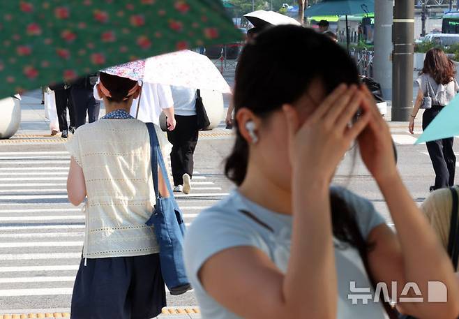 [서울=뉴시스] 최진석 기자 = 폭염이 이어지고 있는 8일 서울 세종대로사거리 인근에서 출근길 시민이 손으로 햇볕을 가리고 있다. 2025.07.08. myjs@newsis.com