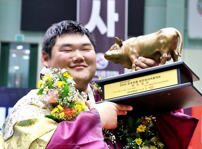 충청북도 보은군 보은국민체육센터에서 열린 '위더스제약 2025 민속씨름보은장사씨름대회' 백두장사(140kg이하)에 등극한 김동현(용인특례시청)이 장사인증서와 황소트로피를 들고 기념사진을 찍고 있다./사진=대한씨름협회 제공