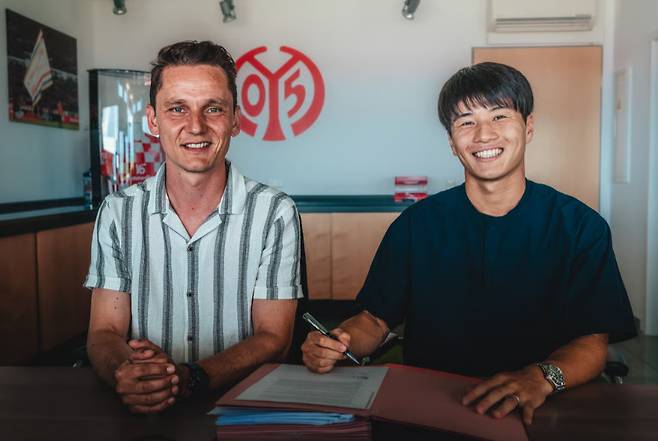 가와사키 소타(오른쪽)가 계약서에 서명 후 미소짓고 있다. /사진=마인츠 공식 홈페이지 갈무리